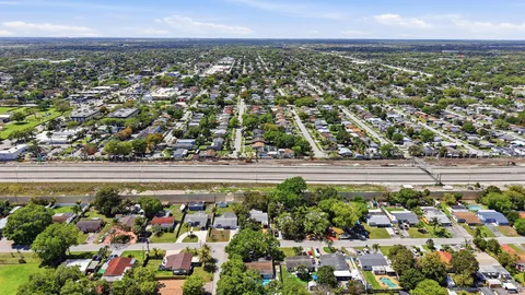 an aerial view of residential houses with outdoor space and swimming pool