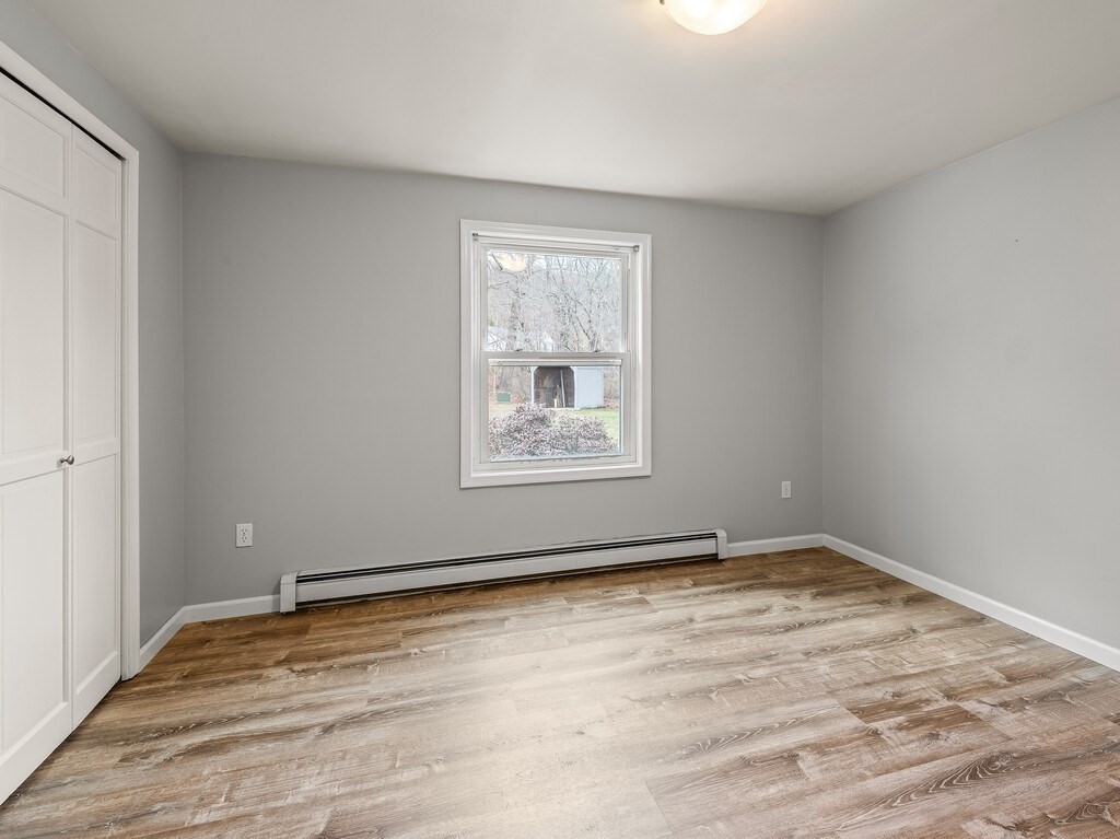 281 Brooks Station Road, Unit 1 Princeton, MA 01541 - Photo 16 of 36 a view of an empty room with wooden floor and a window