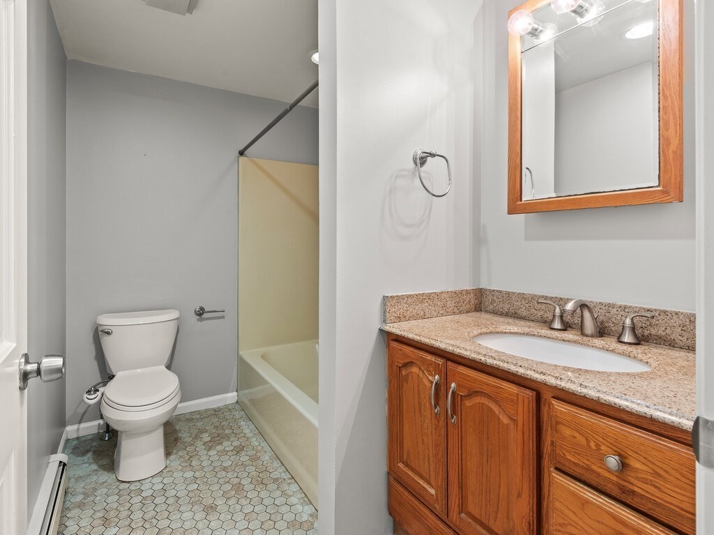 281 Brooks Station Road, Unit 1 Princeton, MA 01541 - Photo 18 of 36 a bathroom with a granite countertop sink a toilet and a mirror