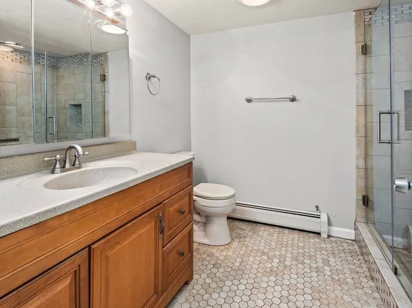 a bathroom with a sink a toilet and shower