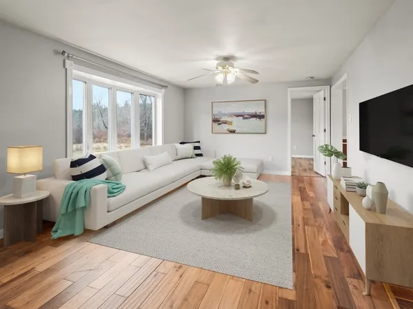 a living room with furniture a flat screen tv and a large window