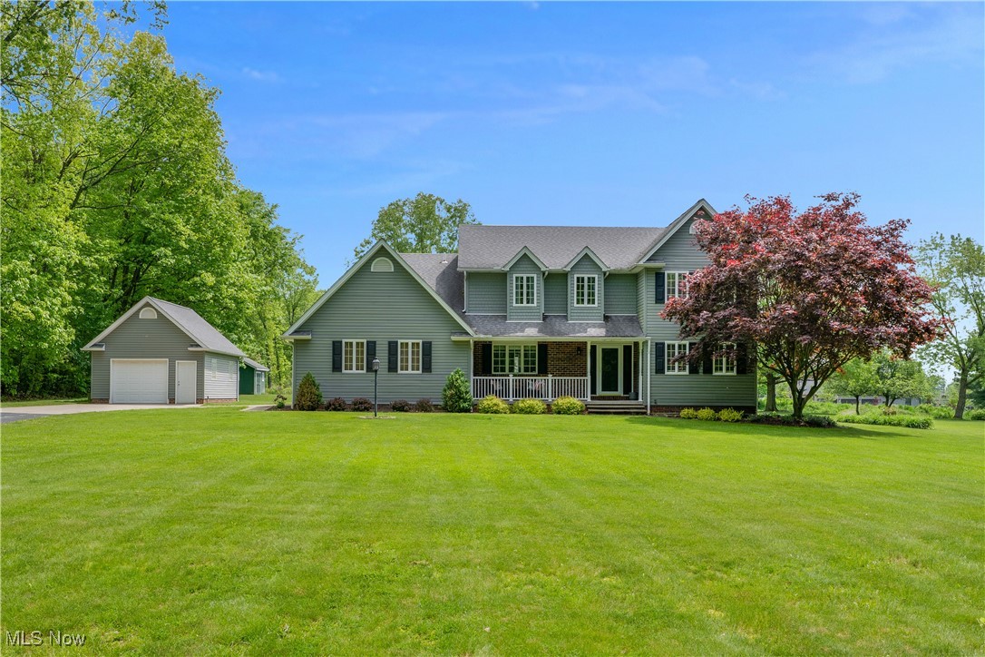 7091 South Raccoon Road Canfield, OH 44406 - Photo 1 of 39 View of front facade with an outbuilding, a garage, covered porch, a front yard, and a shingled roof