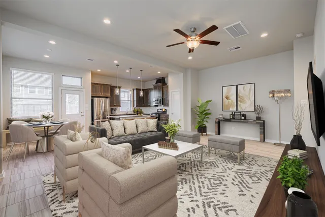 a living room with furniture kitchen view and a large window