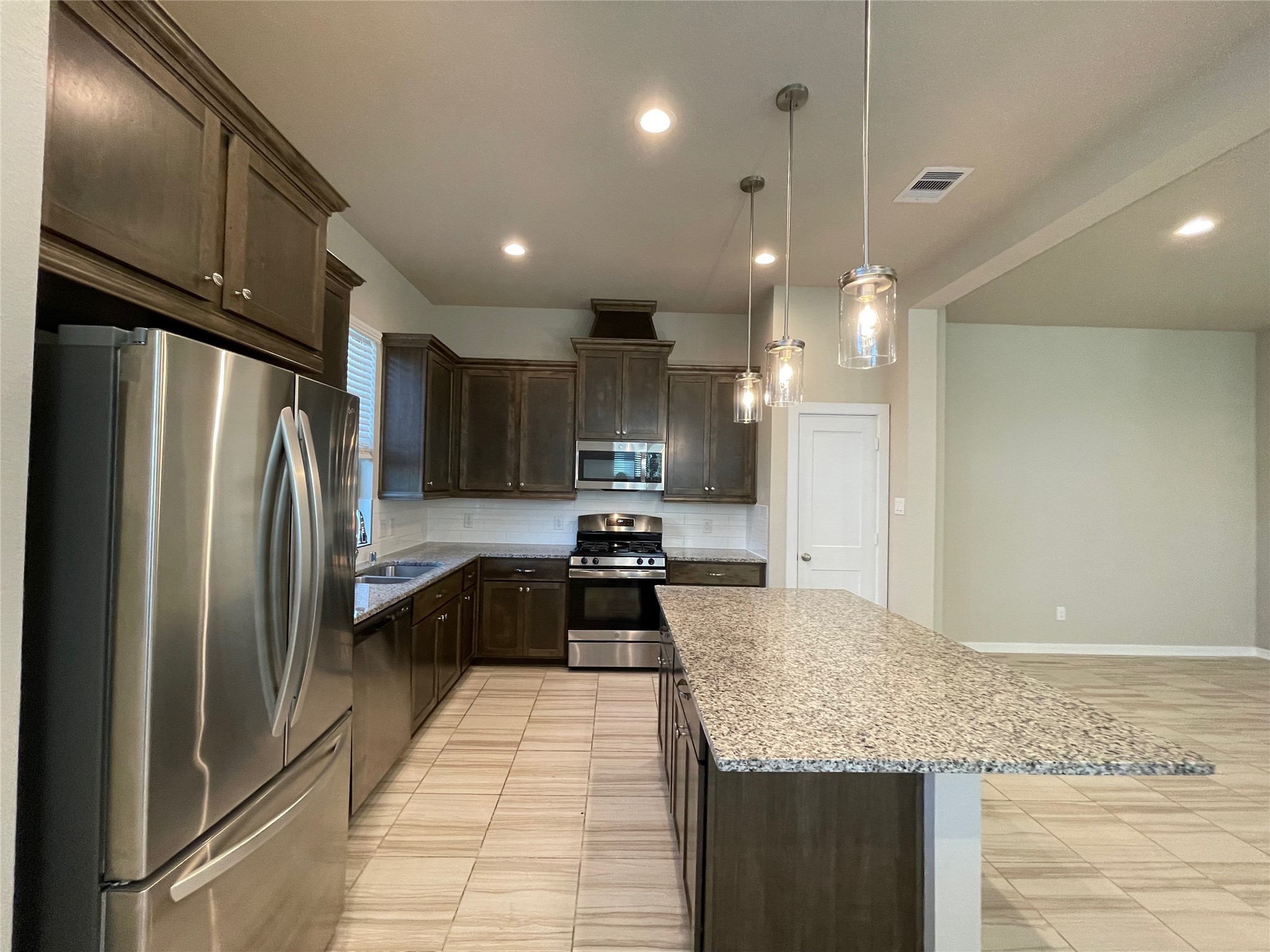 19622 Talley Valley Drive Cypress, TX 77433 - Photo 4 of 18 a kitchen with stainless steel appliances granite countertop a refrigerator a sink and a stove