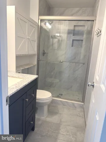 a bathroom with a granite countertop sink toilet and shower