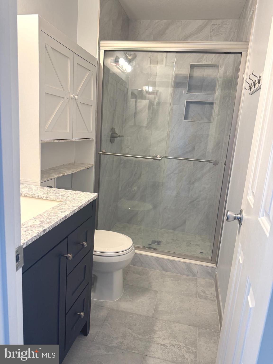 114 Prosperity Avenue Southeast, Unit C Leesburg, VA 20175 - Photo 13 of 18 a bathroom with a granite countertop sink toilet and shower