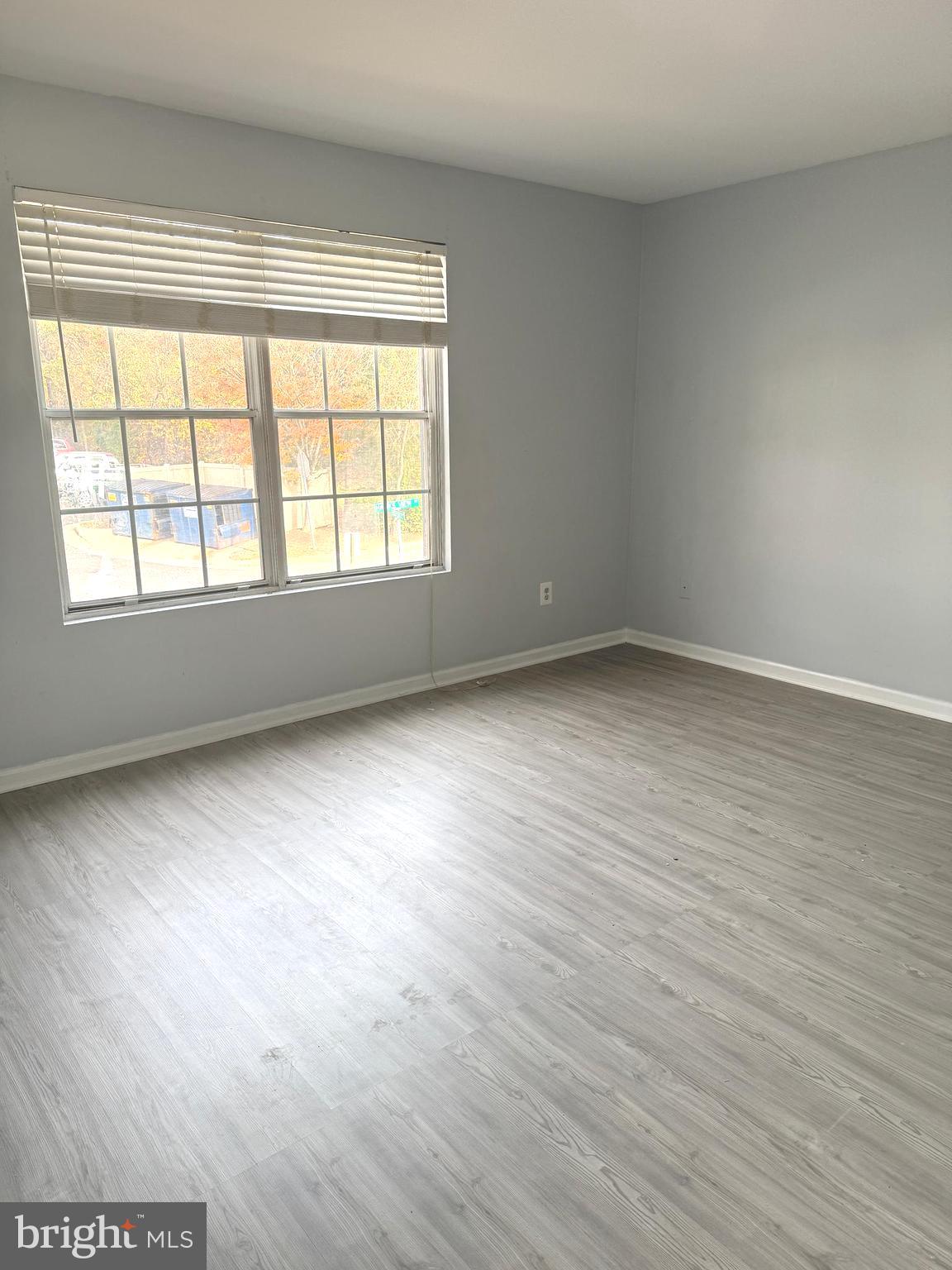 114 Prosperity Avenue Southeast, Unit C Leesburg, VA 20175 - Photo 15 of 18 an empty room with wooden floor and windows