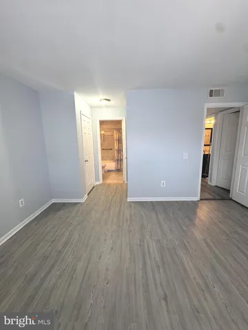 an empty room with wooden floor and mirror