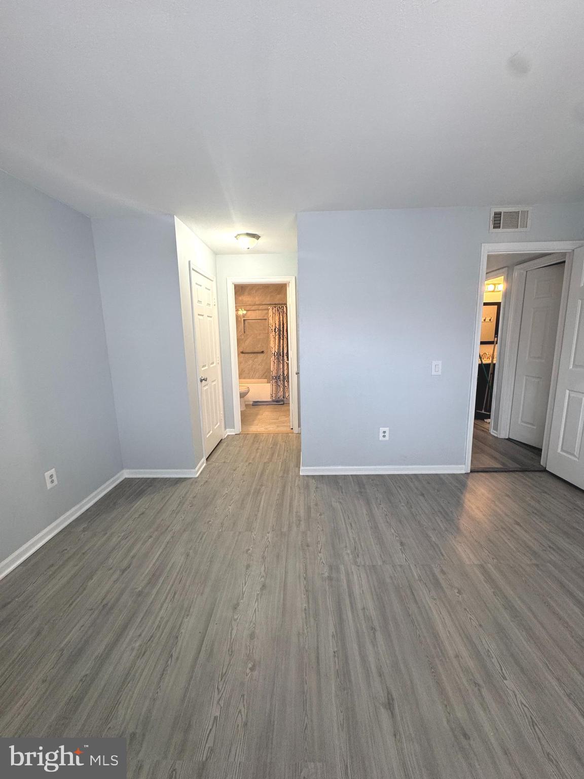 114 Prosperity Avenue Southeast, Unit C Leesburg, VA 20175 - Photo 16 of 18 an empty room with wooden floor and mirror