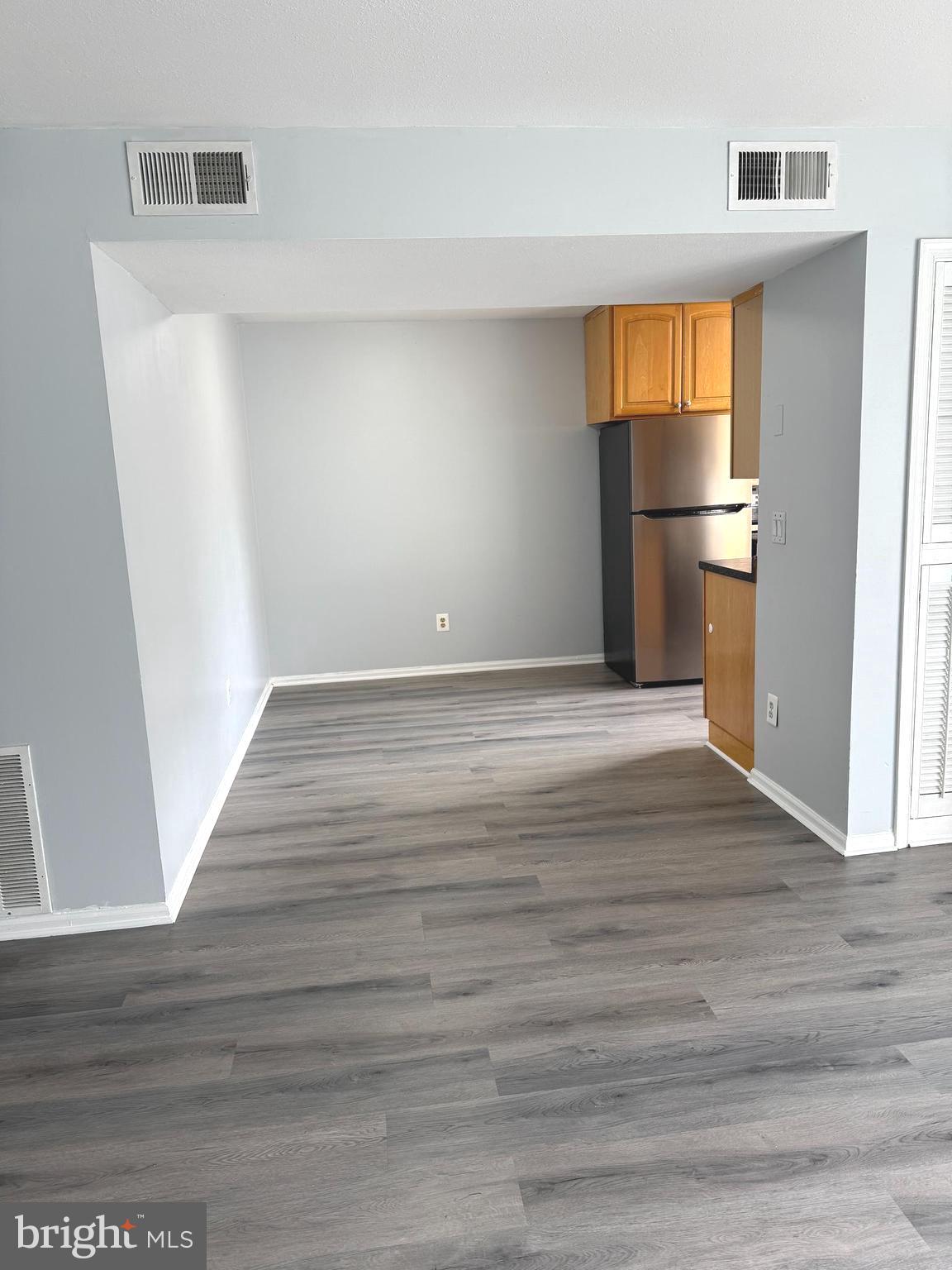 114 Prosperity Avenue Southeast, Unit C Leesburg, VA 20175 - Photo 7 of 18 a view of empty room with wooden floor and kitchen