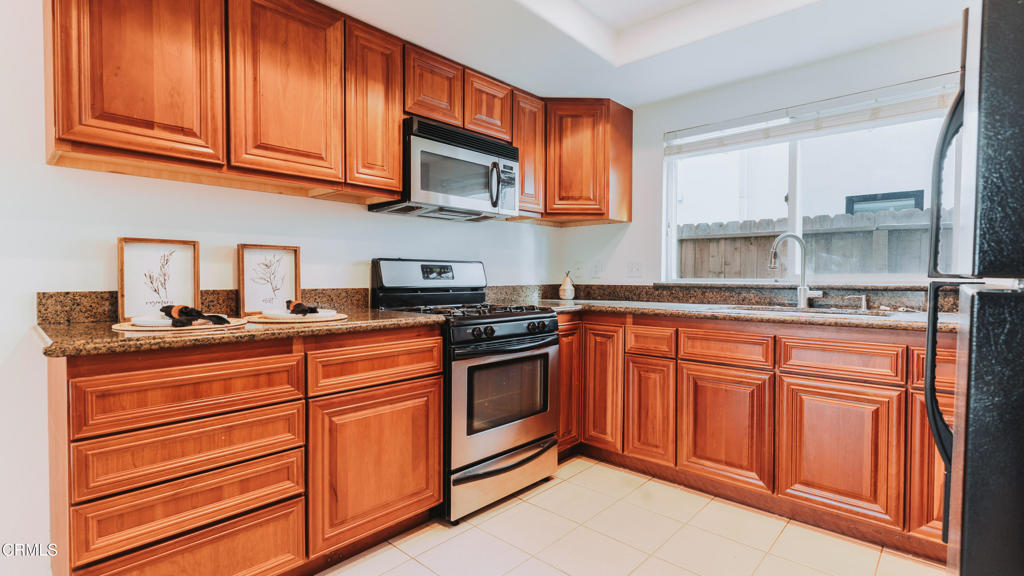 1020 Dunes Street Oxnard, CA 93035 - Photo 17 of 75 a kitchen with stainless steel appliances granite countertop a stove microwave and cabinets
