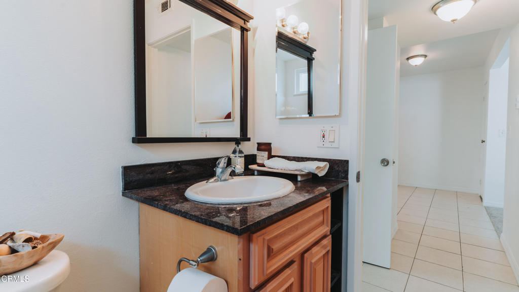 1020 Dunes Street Oxnard, CA 93035 - Photo 21 of 75 a bathroom with a granite countertop sink and a mirror