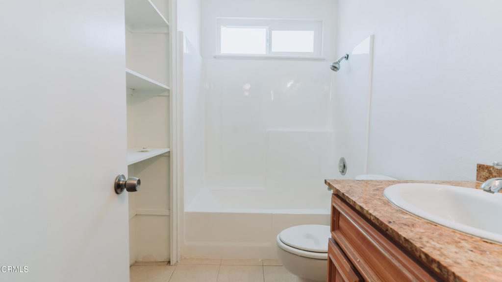1020 Dunes Street Oxnard, CA 93035 - Photo 30 of 75 a bathroom with a granite countertop sink a toilet a mirror and shower