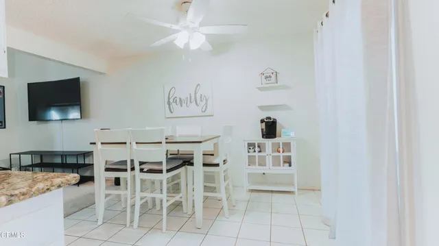 a spacious bedroom with a bed and a flat tv screen on dresser