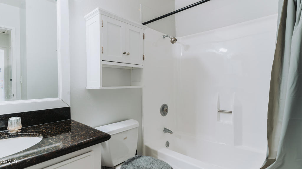 1020 Dunes Street Oxnard, CA 93035 - Photo 62 of 75 a bathroom with a granite countertop sink a toilet and shower