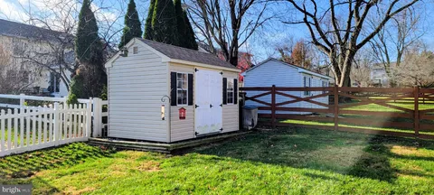 a view of a yard with wooden fence
