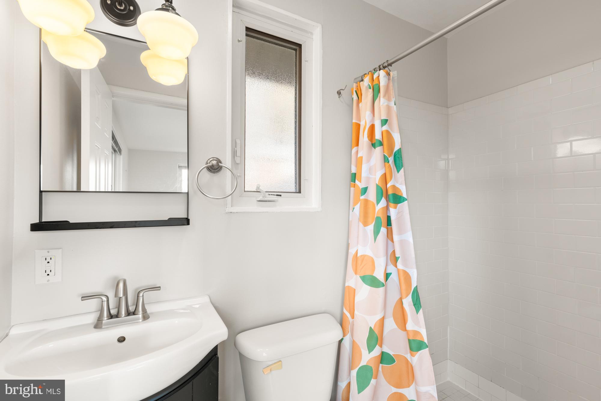 2407 Harmon Road Silver Spring, MD 20902 - Photo 28 of 39 a bathroom with a sink a mirror and a shower curtain
