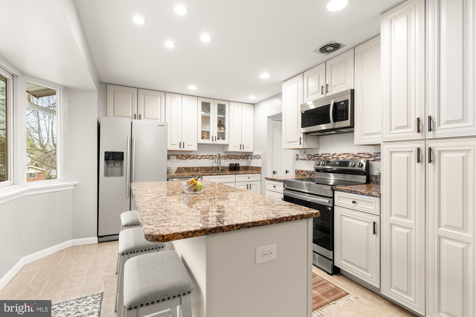 2407 Harmon Road Silver Spring, MD 20902 - Photo 10 of 39 a kitchen with stainless steel appliances granite countertop a refrigerator sink stove microwave and cabinets