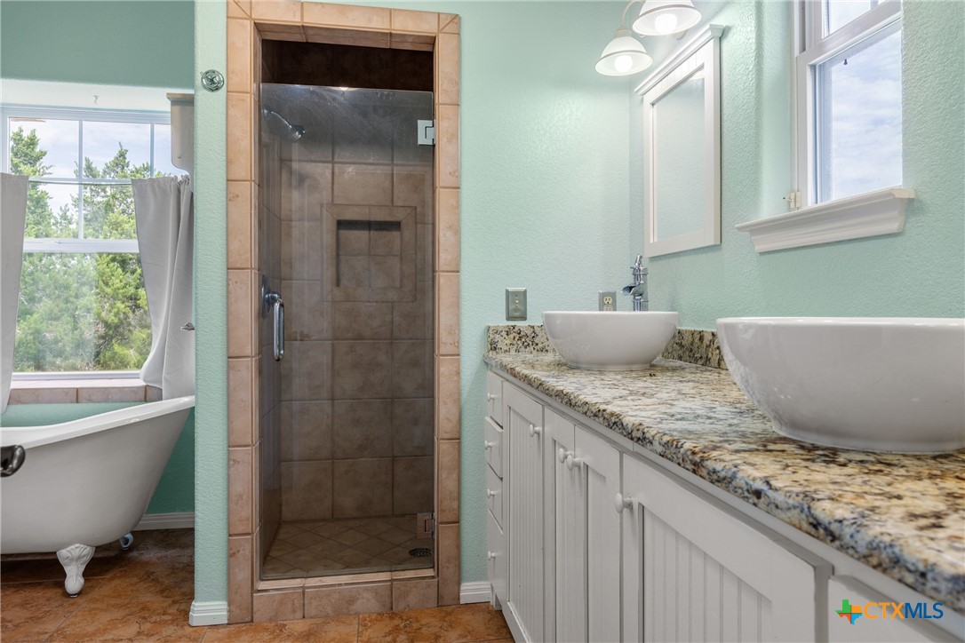 845 Rutherford Fischer, TX 78623 - Photo 16 of 39 a bathroom with a granite countertop sink and mirror