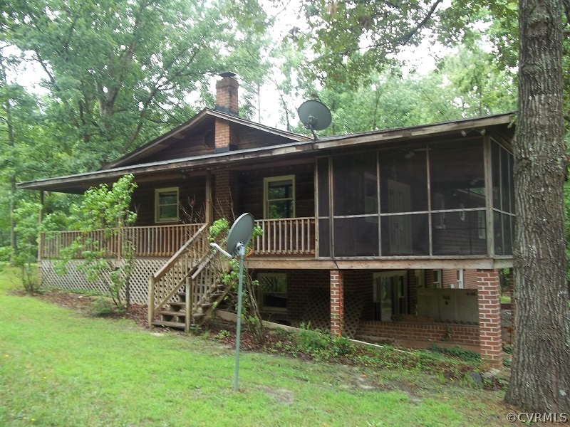 4418 Tatum Road Disputanta, VA 23842 - Photo 1 of 8 a view of a house with a large window and a yard with wooden fence