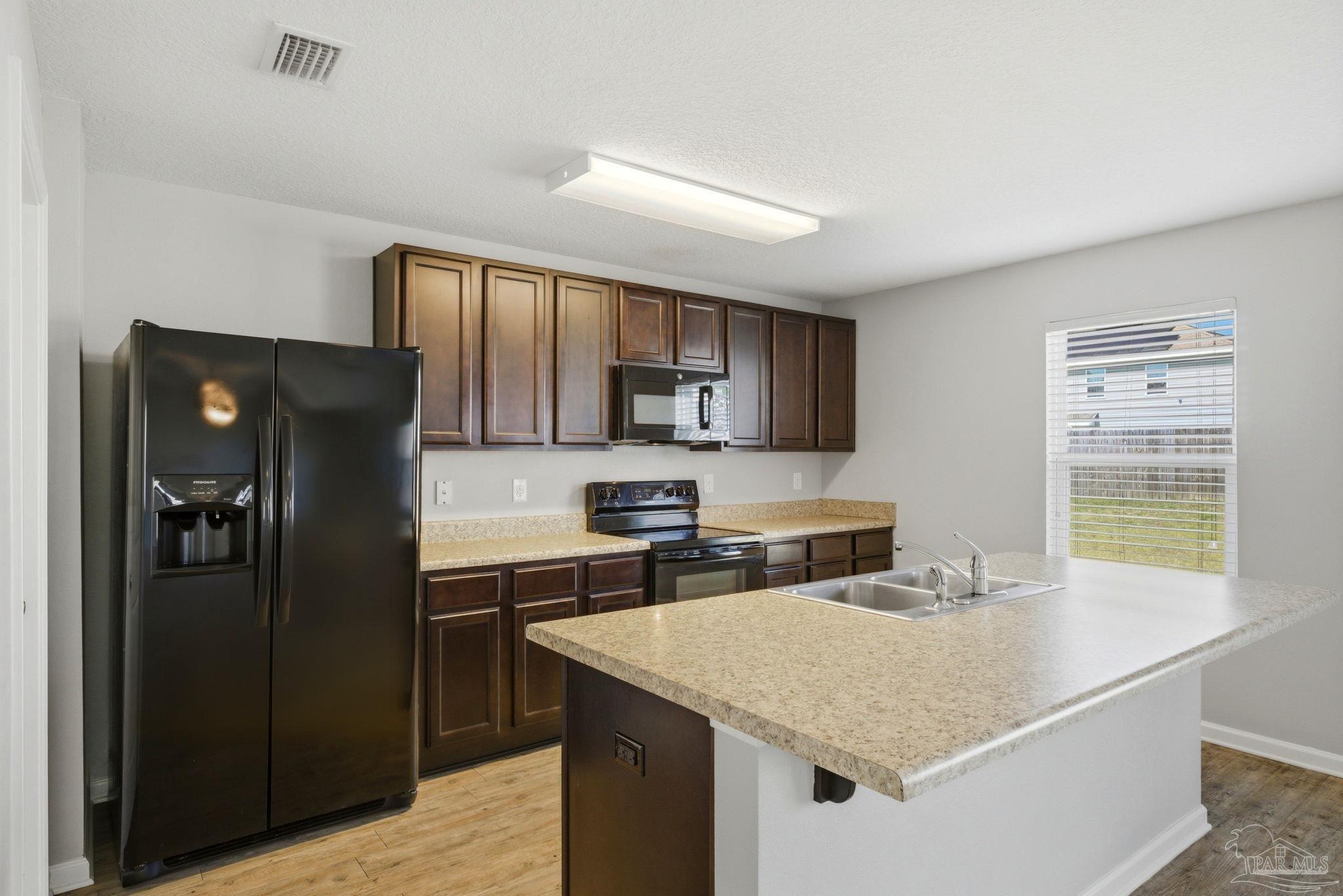 5881 Bay Tree Court Milton, FL 32570 - Photo 11 of 51 a kitchen with stainless steel appliances granite countertop a refrigerator a sink a stove and island
