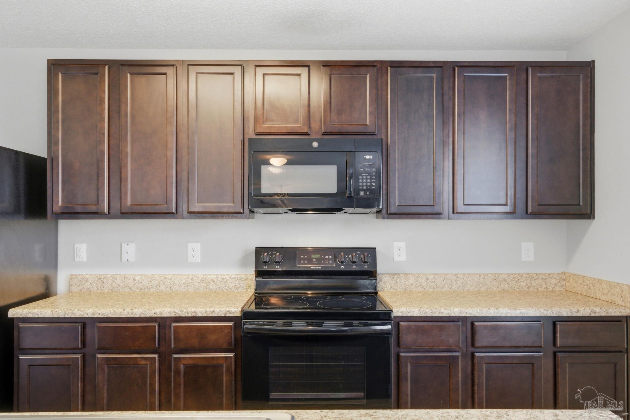 5881 Bay Tree Court Milton, FL 32570 - Photo 12 of 51 a kitchen with granite countertop a stove top oven cabinetry and granite counter tops