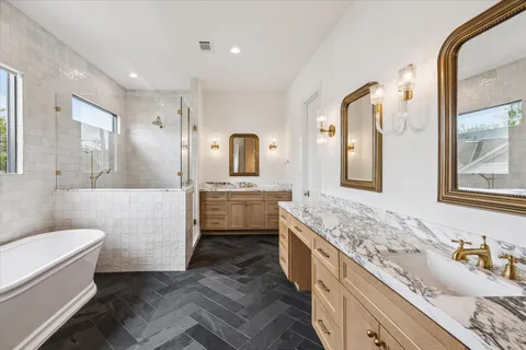 a bathroom with a granite countertop sink mirror vanity bathtub and toilet