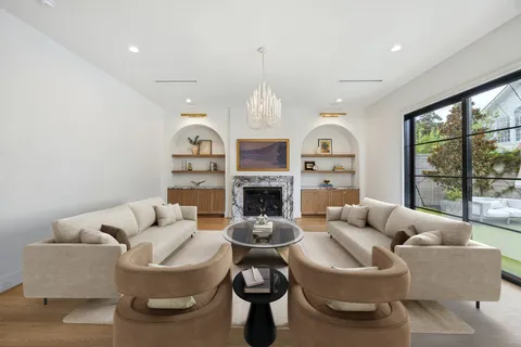 a living room with furniture a fireplace and a large window
