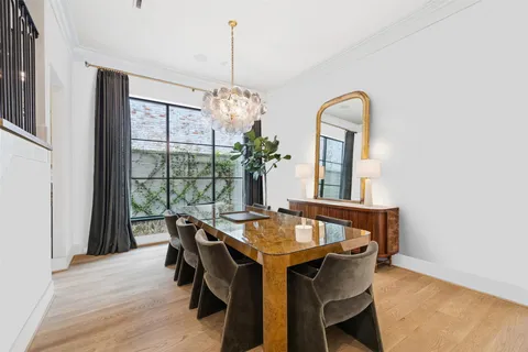a dining room with furniture a chandelier and wooden floor