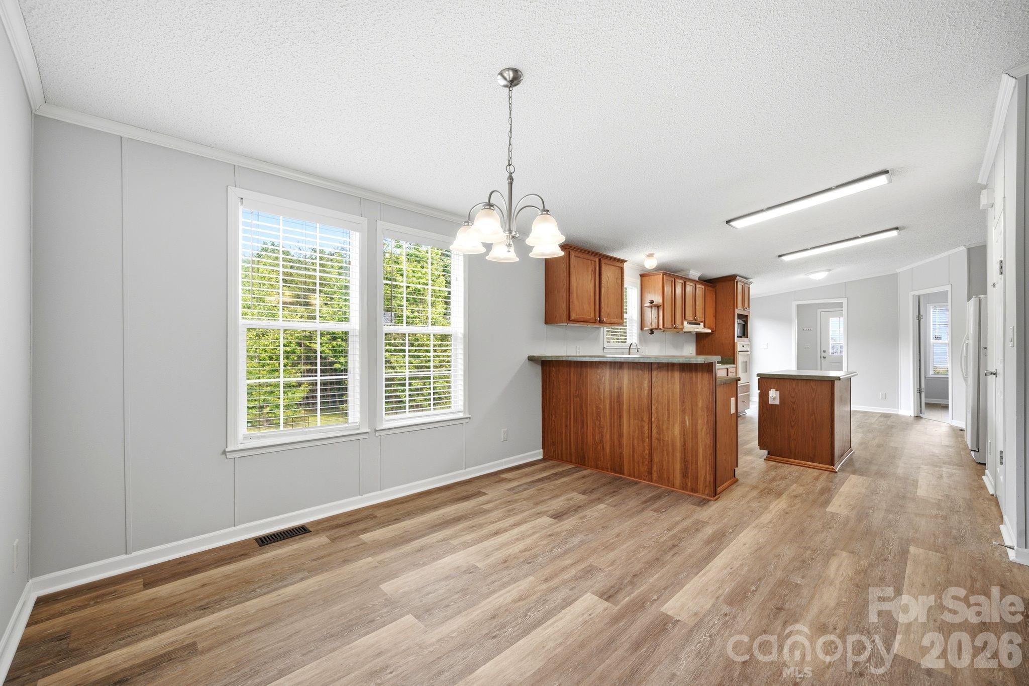 2368 Beth Haven Church Road Denver, NC 28037 - Photo 23 of 42 a open kitchen with kitchen island granite countertop wooden floors and wide window
