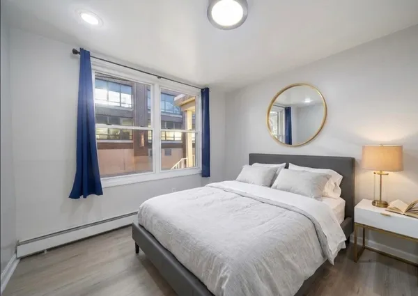 a bedroom with a bed and a large window