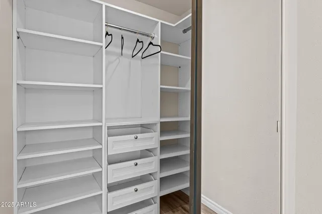 a view of walk in closet with empty racks