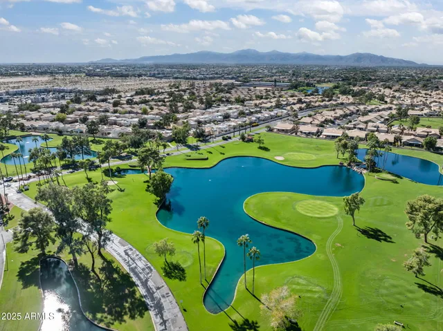 an aerial view of a swimming pool a yard and mountain view in back
