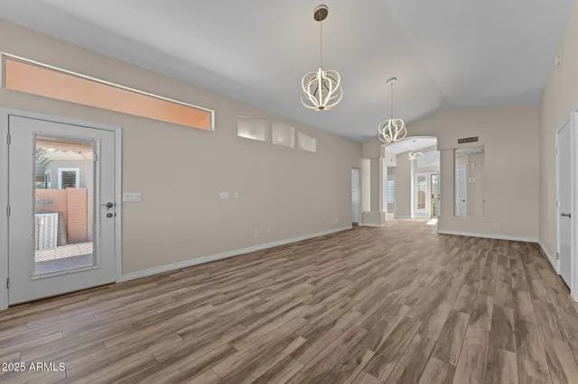 a view of empty room with wooden floor