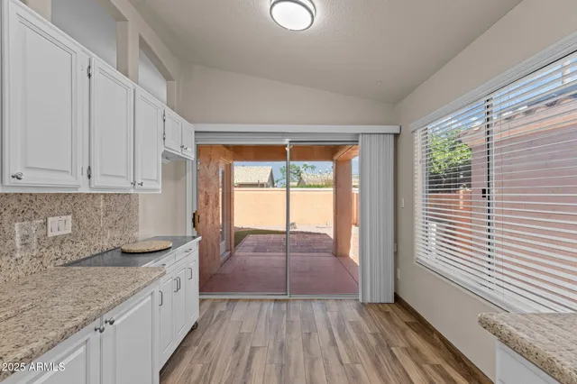 a kitchen with wooden floors and wide window