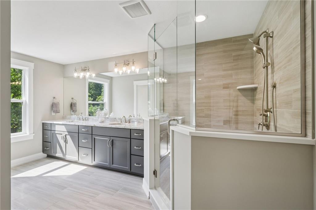 102 Bartlett Lane Wexford, PA 15090 - Photo 26 of 40 a bathroom with a double vanity sink a large mirror and a bathtub