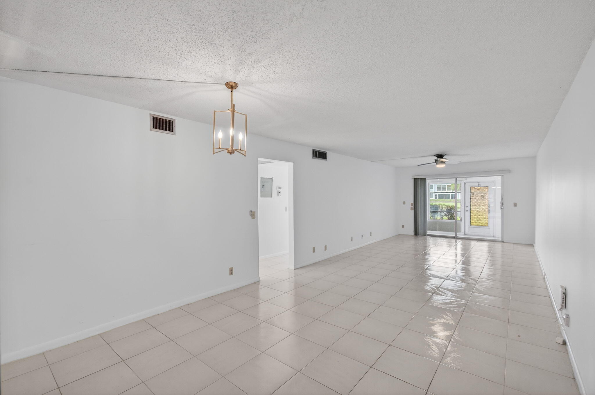 1036 Hythe B, Unit B Boca Raton, FL 33434 - Photo 10 of 53 an empty room with chandelier fan and windows