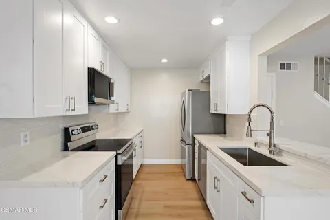 a kitchen with a sink stove and cabinets
