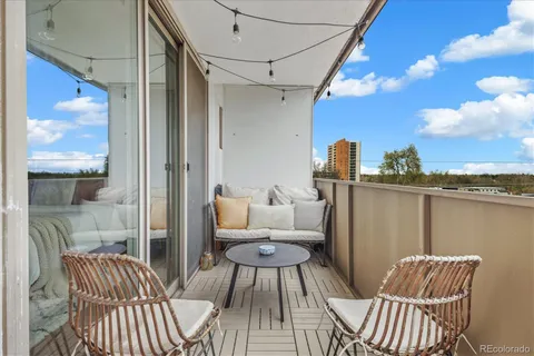 a view of a balcony with two chairs and a potted plant