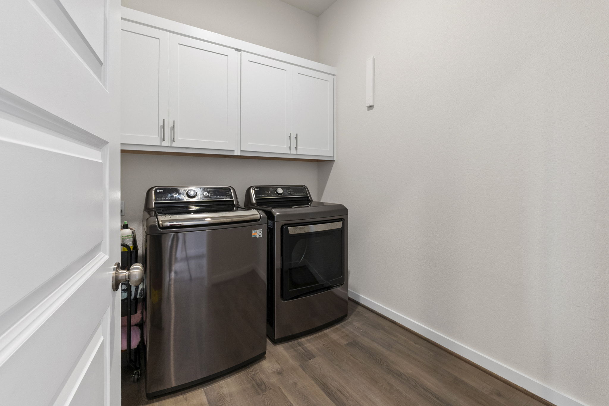 460 Constitution Way Kyle, TX 78640 - Photo 38 of 40 Dedicated laundry room featuring white shaker cabinetry with brushed nickel hardware, wood-finish flooring, and white baseboards