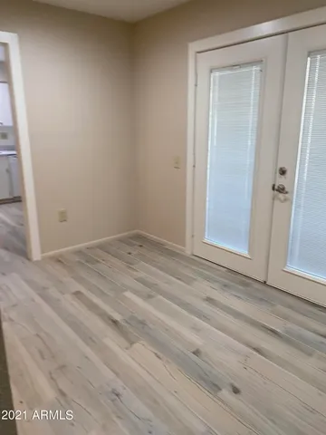 an empty room with wooden floor and sliding door
