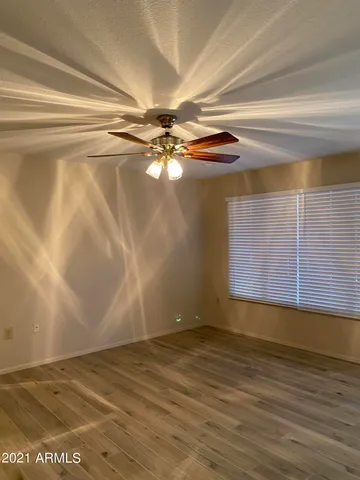 a view of a room with wooden floor and a ceiling fan