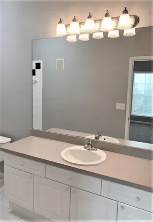 a bathroom with a sink vanity and a mirror