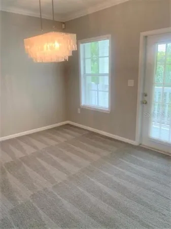 an empty room with window and chandelier fan