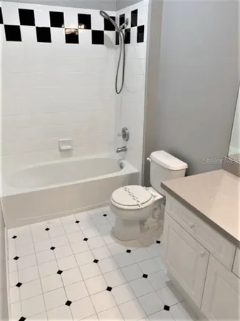 a white toilet sitting next to a bathroom sink and a shower