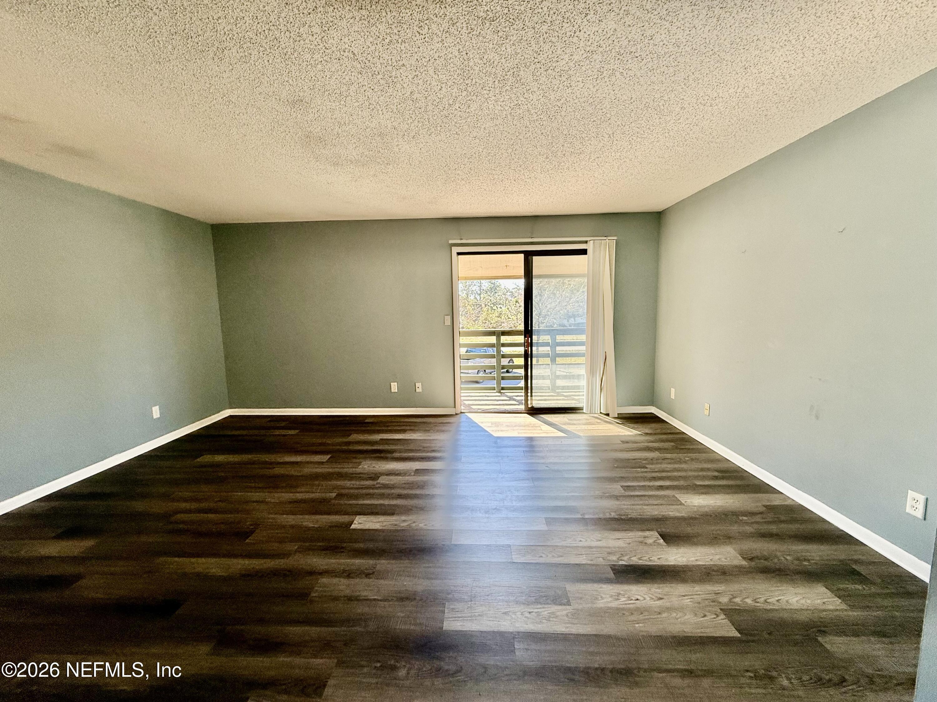 3765 Crown Point Road, Unit 13 Jacksonville, FL 32257 - Photo 22 of 37 a view of an empty room with wooden floor and a window