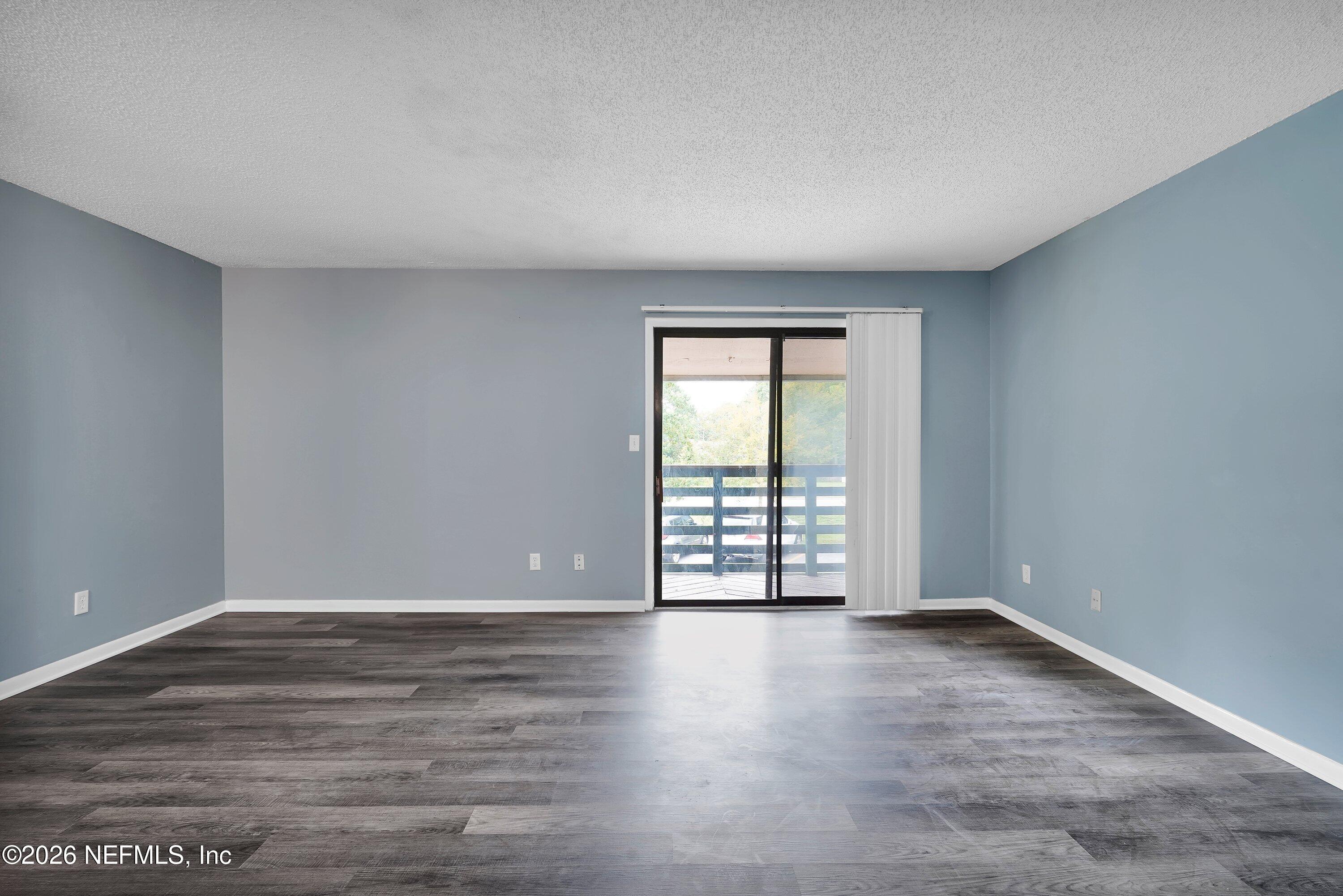 3765 Crown Point Road, Unit 13 Jacksonville, FL 32257 - Photo 9 of 37 a view of an empty room with wooden floor and a window