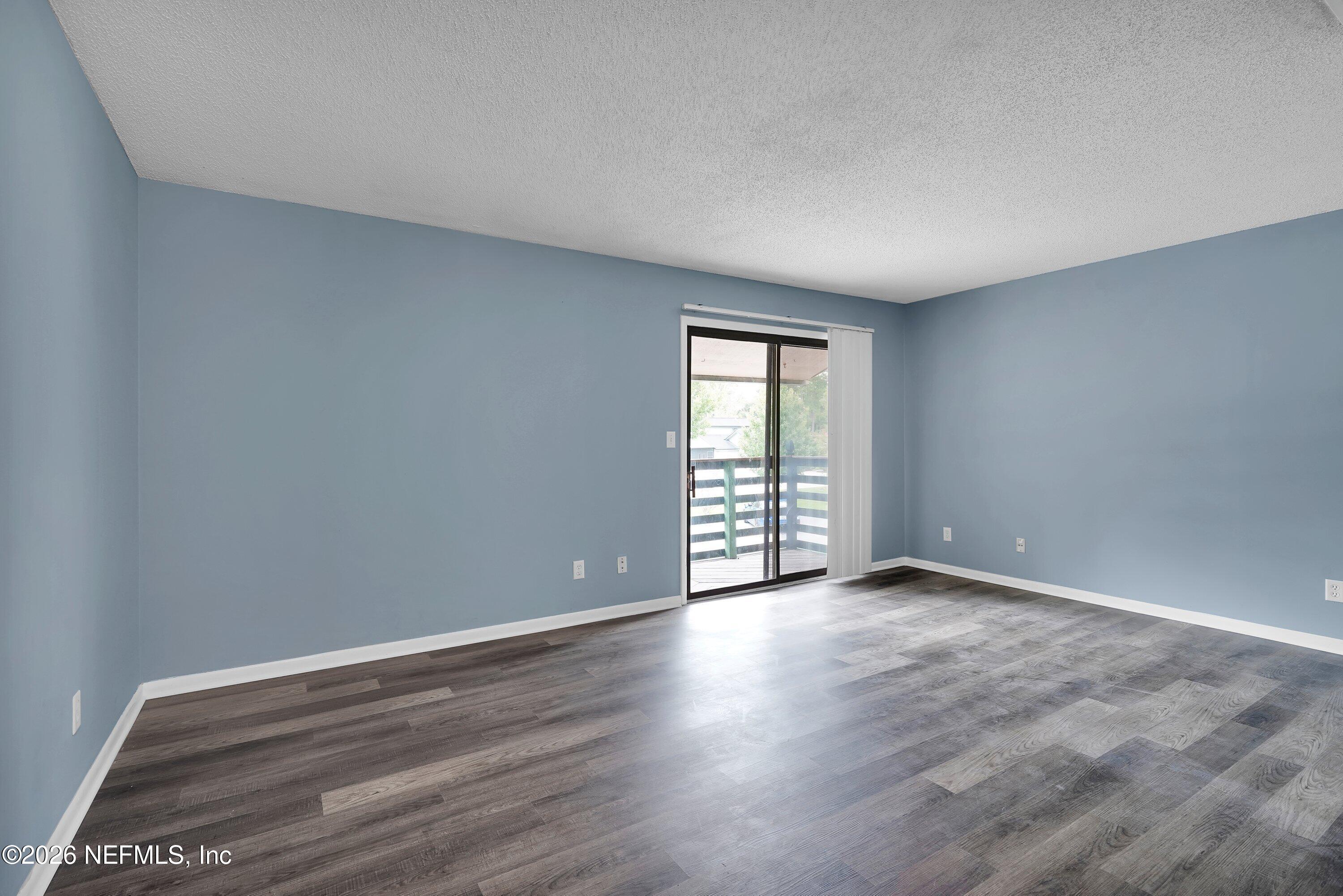 3765 Crown Point Road, Unit 13 Jacksonville, FL 32257 - Photo 10 of 37 a view of an empty room with wooden floor and a window