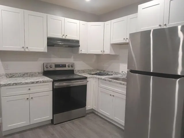 a kitchen with refrigerator a stove and cabinets