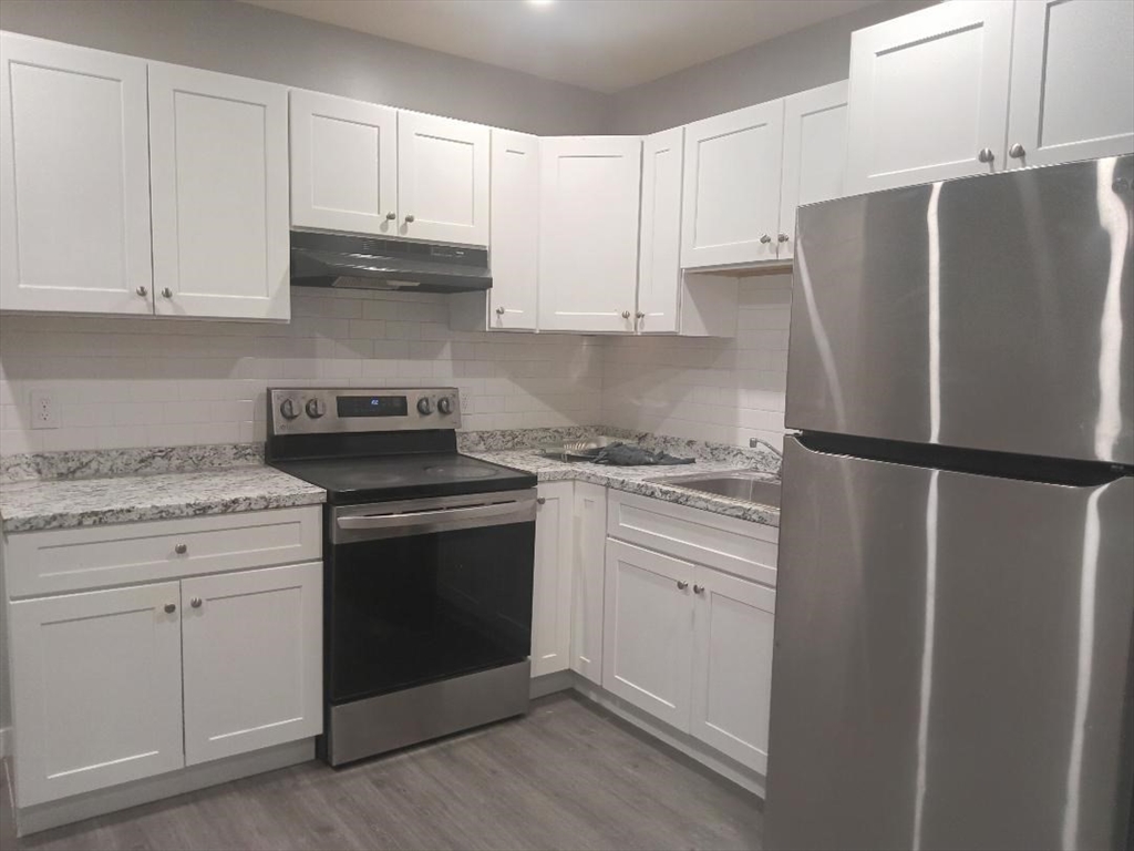 a kitchen with refrigerator a stove and cabinets